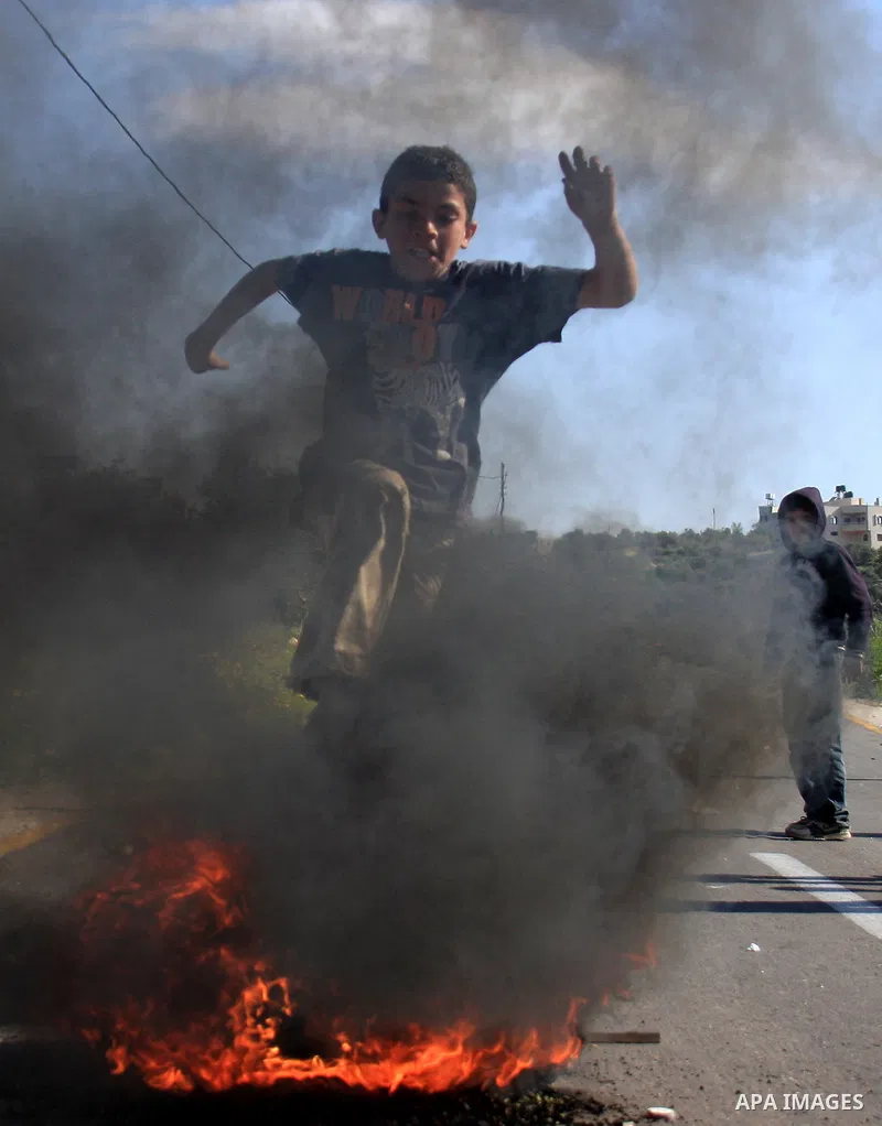 Palestinian youths throw stones at Israeli soldiers during which clashes erupted following an Israeli army operation in the village of Awarta near the West Bank city of Nablus, Sunday, April 10, 2011. The Israeli army of...