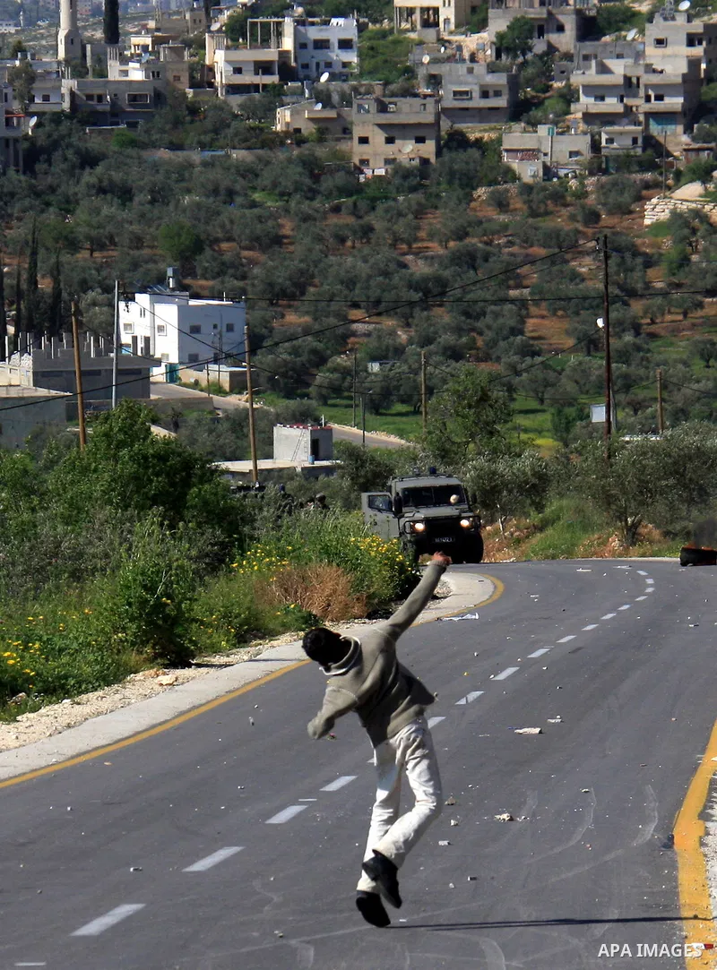 Palestinian youths throw stones at Israeli soldiers during which clashes erupted following an Israeli army operation in the village of Awarta near the West Bank city of Nablus, Sunday, April 10, 2011. The Israeli army of...