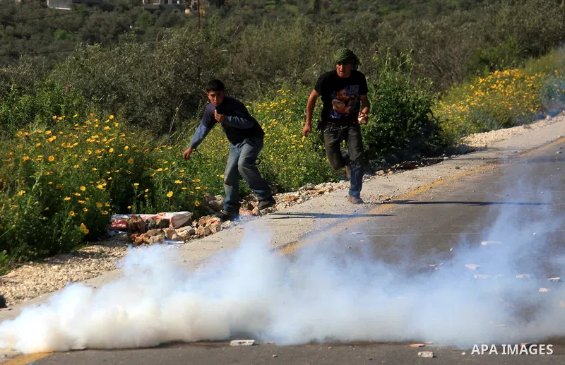 Palestinian youths run away from tear gas after throwing stones at Israeli border police during clashes outside the village of Awarta near the West Bank city of Nablus, Sunday, April 10, 2011. The Israeli army often carr...