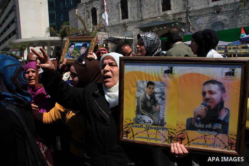 Palestinian women hold pictures of relatives during a protest calling for the release of Palestinian prisoners from Israeli jails, in the West Bank city of Nablus , Sunday, April 10, 2011. Israel currently holds about 8,...