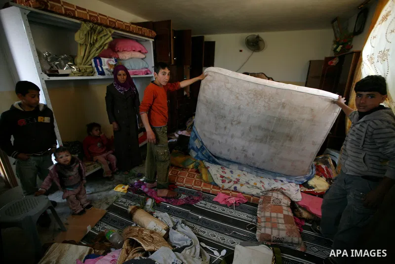 Palestinians inspect damage in their house in the West Bank village of Awarta near Nablus April 11, 2011, which they say was caused by an Israeli army raid. The Israeli army often carries out raids in West Bank towns and...