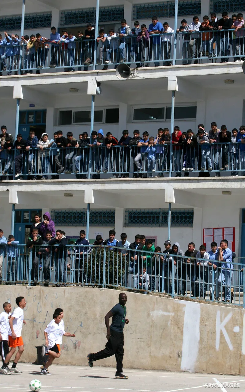 Former French soccer player Lilian Thuram visits a school in the West bank refugee camp of Kalandia, on 11 April 2011. Thuram is visiting the Palestinian territory in support of the education programme funded by France t...