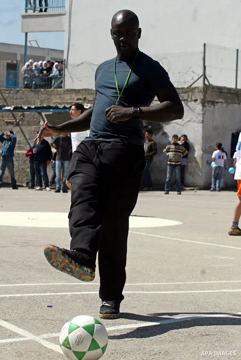 Former French soccer player Lilian Thuram visits a school in the West bank refugee camp of Kalandia, on 11 April 2011. Thuram is visiting the Palestinian territory in support of the education programme funded by France t...