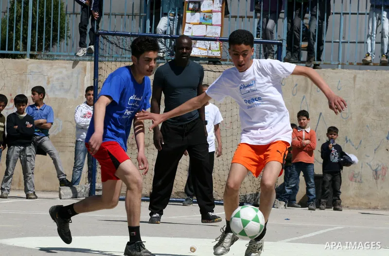 Former French soccer player Lilian Thuram visits a school in the West bank refugee camp of Kalandia, on 11 April 2011. Thuram is visiting the Palestinian territory in support of the education programme funded by France t...