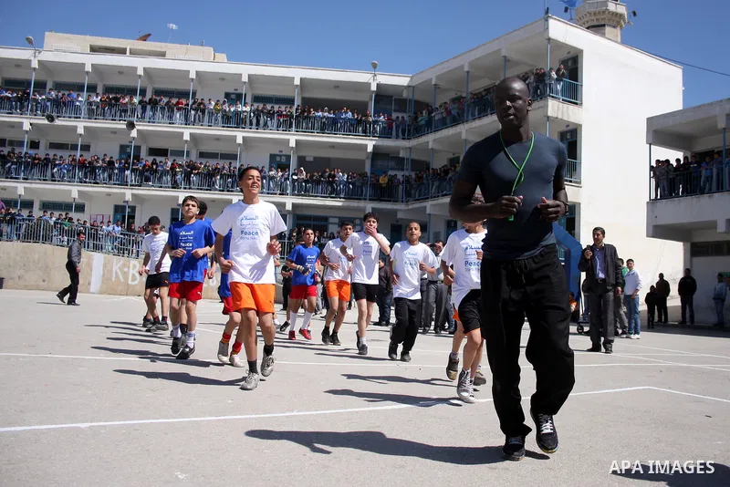 Former French soccer player Lilian Thuram visits a school in the West bank refugee camp of Kalandia, on 11 April 2011. Thuram is visiting the Palestinian territory in support of the education programme funded by France t...
