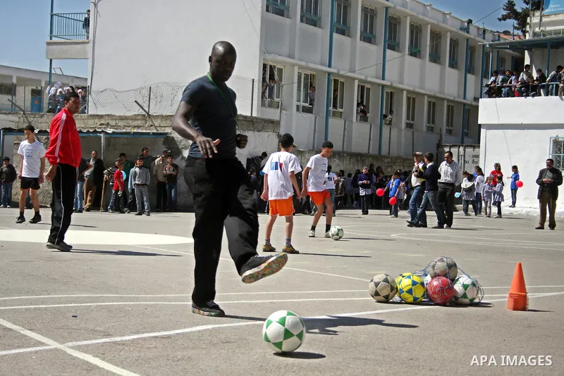 Former French soccer player Lilian Thuram visits a school in the West bank refugee camp of Kalandia, on 11 April 2011. Thuram is visiting the Palestinian territory in support of the education programme funded by France t...