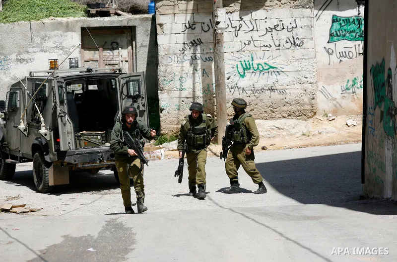 Israeli troops carry out a search operation in the West Bank village of Awarta on April 12, 2011 as the northern West Bank village has been the centre of a massive army hunt for the killers responsible for grisly stabbin...