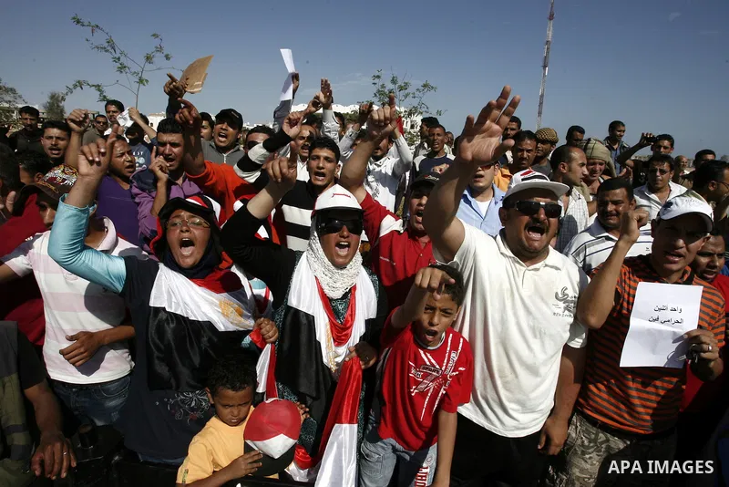 Egyptian protesters shout slogans and wave the national flag outside the Sharm el Sheikh International Hospital where the ousted Egyptian leader Hosni Mubarak was admitted after suffering medical complications during que...