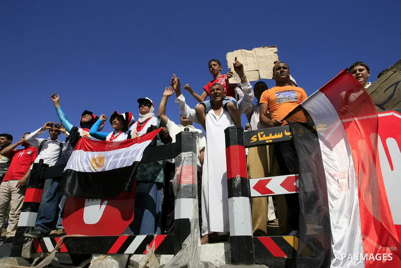 Egyptian protesters shout slogans and wave the national flag outside the Sharm el Sheikh International Hospital where the ousted Egyptian leader Hosni Mubarak was admitted after suffering medical complications during que...