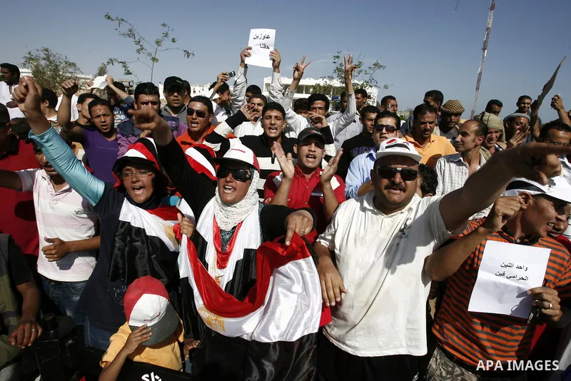 Egyptian protesters shout slogans and wave the national flag outside the Sharm el Sheikh International Hospital where the ousted Egyptian leader Hosni Mubarak was admitted after suffering medical complications during que...