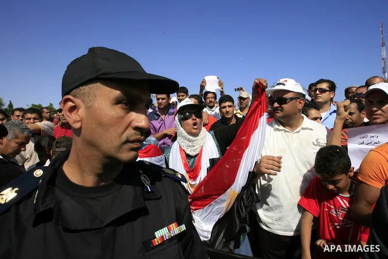Egyptian protesters shout slogans and wave the national flag outside the Sharm el Sheikh International Hospital where the ousted Egyptian leader Hosni Mubarak was admitted after suffering medical complications during que...