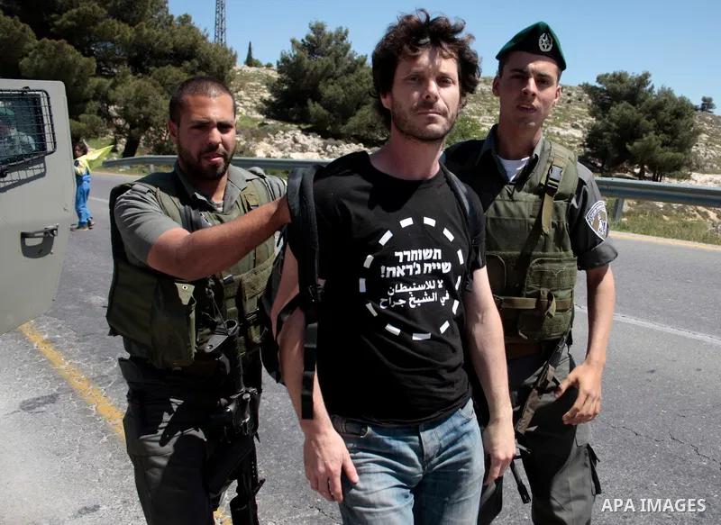 Israeli soldiers arrest a protester during a demonstration against Israel's controversial separation barrier and in support with Vittorio Arrigoni after kidnapping him in Gaza, in the West Bank village of Maasarah, near...