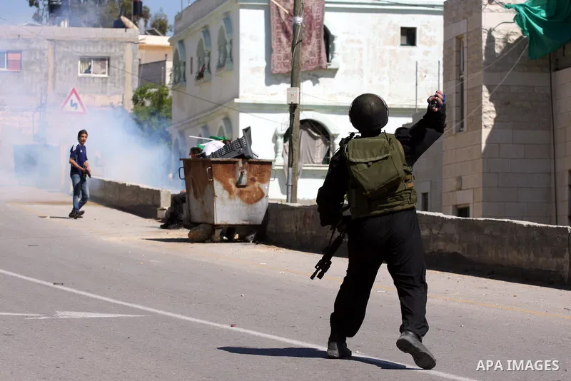 Palestinian and foreign demonstrators run away from tear gas fired by Israeli soldiers to disperse a protest against the expropriation of land to expand the Jewish settlement of Halmish, in the Palestinian village of Nab...
