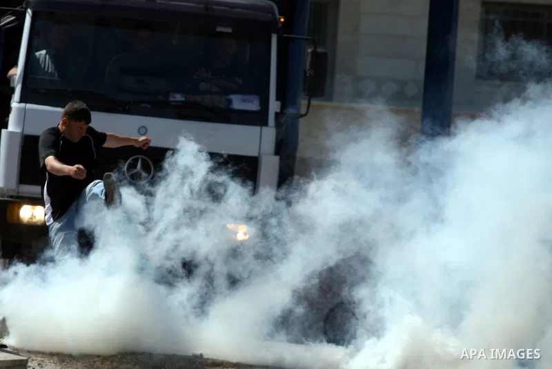 Palestinian and foreign demonstrators run away from tear gas fired by Israeli soldiers to disperse a protest against the expropriation of land to expand the Jewish settlement of Halmish, in the Palestinian village of Nab...