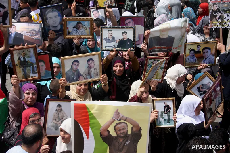 Palestinians hold pictures of their relatives who are imprisoned in an Israeli jail during a protest for the Prisoners Day which will be held on Sunday, in the West Bank city of Ramallah April 16, 2011. Photo by Issam Ri...