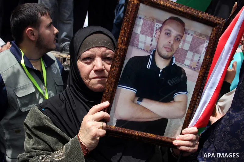 Palestinians hold pictures of their relatives who are imprisoned in an Israeli jail during a protest for the Prisoners Day which will be held on Sunday, in the West Bank city of Ramallah April 16, 2011. Photo by Issam Ri...