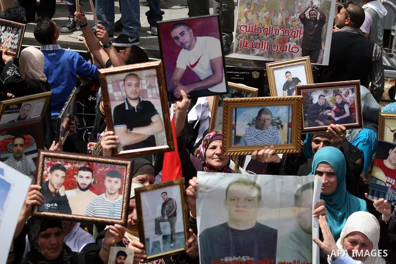 Palestinians hold pictures of their relatives who are imprisoned in an Israeli jail during a protest for the Prisoners Day which will be held on Sunday, in the West Bank city of Ramallah April 16, 2011. Photo by Issam Ri...