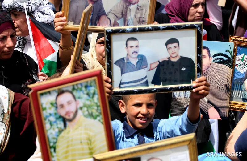 Palestinians hold pictures of their relatives who are imprisoned in an Israeli jail during a protest for the Prisoners Day which will be held on Sunday, in the West Bank city of Ramallah April 16, 2011. Photo by Issam Ri...
