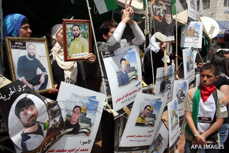 Palestinians hold pictures of their relatives who are imprisoned in an Israeli jail during a protest for the Prisoners Day which will be held on Sunday, in the West Bank city of Ramallah April 16, 2011. Photo by Issam Ri...