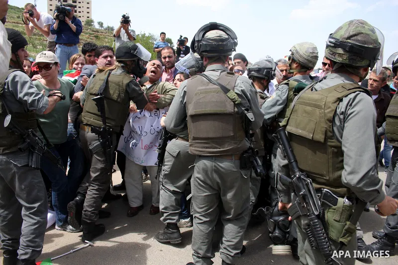 Palestinians and foreigners argue with Israeli soldiers during a protest outside Ofer prison, near the West Bank city of Ramallah, April 17, 2011, calling for the release of Palestinian prisoners from Israeli jails. Apri...