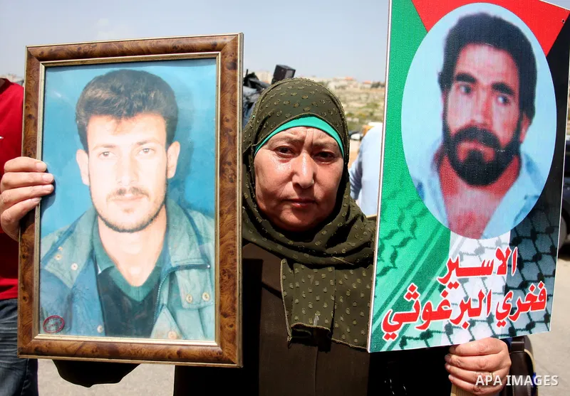 Palestinians hold pictures of their jailed relatives during a protest outside Ofer prison, near the West Bank city of Ramallah, April 17, 2011, calling for the release of Palestinian prisoners from Israeli jails. April 1...