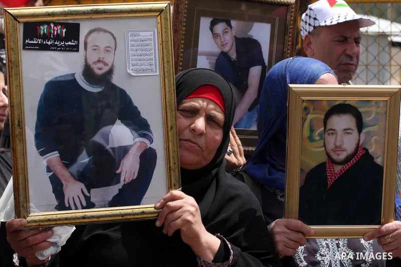 Palestinians hold pictures of their jailed relatives during a protest outside Ofer prison, near the West Bank city of Ramallah, April 17, 2011, calling for the release of Palestinian prisoners from Israeli jails. April 1...
