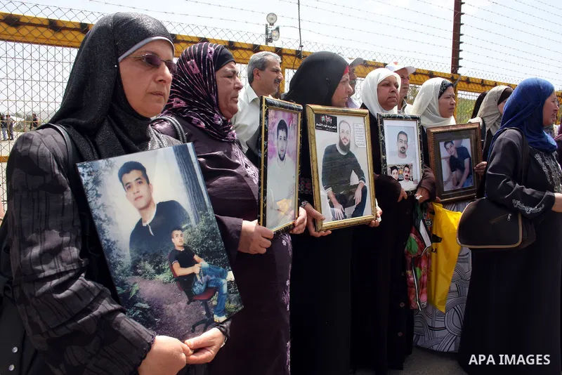 Palestinians hold pictures of their jailed relatives during a protest outside Ofer prison, near the West Bank city of Ramallah, April 17, 2011, calling for the release of Palestinian prisoners from Israeli jails. April 1...