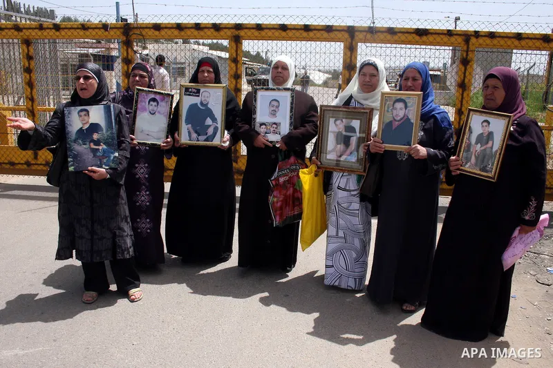 Palestinians hold pictures of their jailed relatives during a protest outside Ofer prison, near the West Bank city of Ramallah, April 17, 2011, calling for the release of Palestinian prisoners from Israeli jails. April 1...