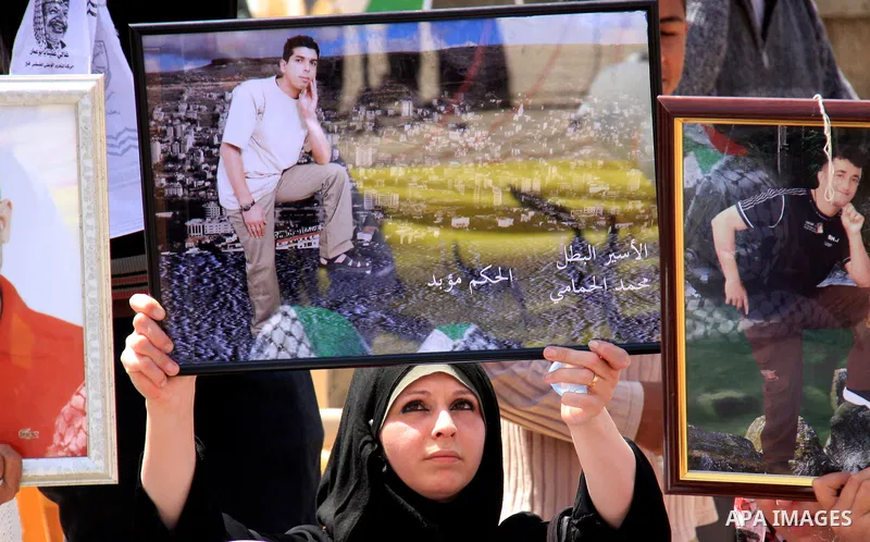 Palestinian women hold photographs of relatives jailed in Israel, during a protest to mark Prisoner's Day in the West Bank city of Nablus, Sunday, April 17, 2011. Some 5,500 Palestinians are held in Israeli prisons accor...
