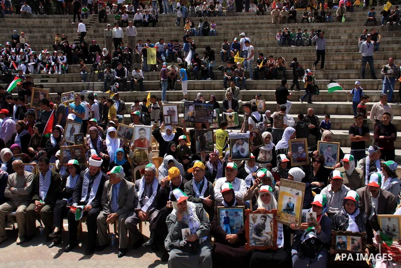 Palestinian women hold photographs of relatives jailed in Israel, during a protest to mark Prisoner's Day in the West Bank city of Nablus, Sunday, April 17, 2011. Some 5,500 Palestinians are held in Israeli prisons accor...