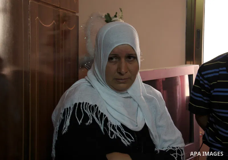 Palestinian Shama Awad, mother of Amjad Awad, suspected in a stabbing attack that killed Jewish settler family, talks to journalists at her home in the West Bank village of Awarta near Nablus, Sunday, April 17, 2011. Isr...