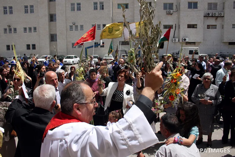 Palestinian Christians take part on Orthodox Palm Sunday in the West Bank city of Ramallah, Sunday, April 17, 2011. Palm Sunday commemorates Jesus Christ's triumphant entry into Jerusalem, and is the start of the church'...