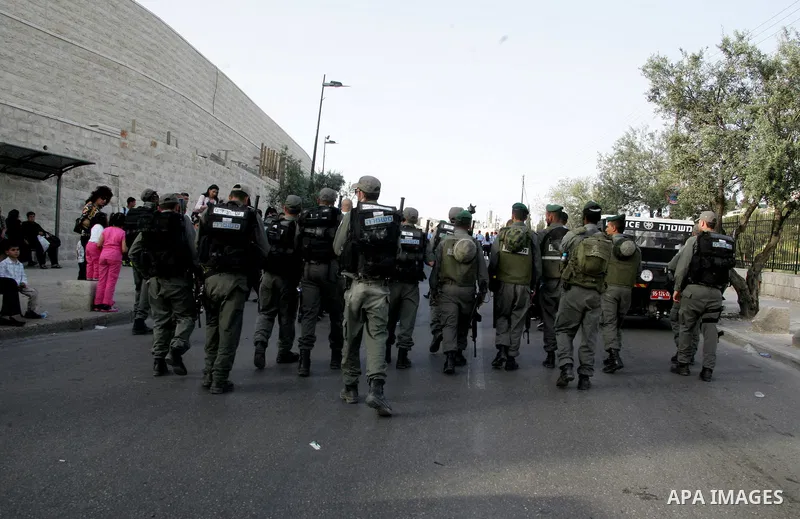 Israeli troops stand guard as Christian pilgrims take part the Palm Sunday procession from Mt. Olives into Jerusalem's old city on April 17, 2011, marking the triumphant return of Jesus Christ to Jerusalem when a cheerin...