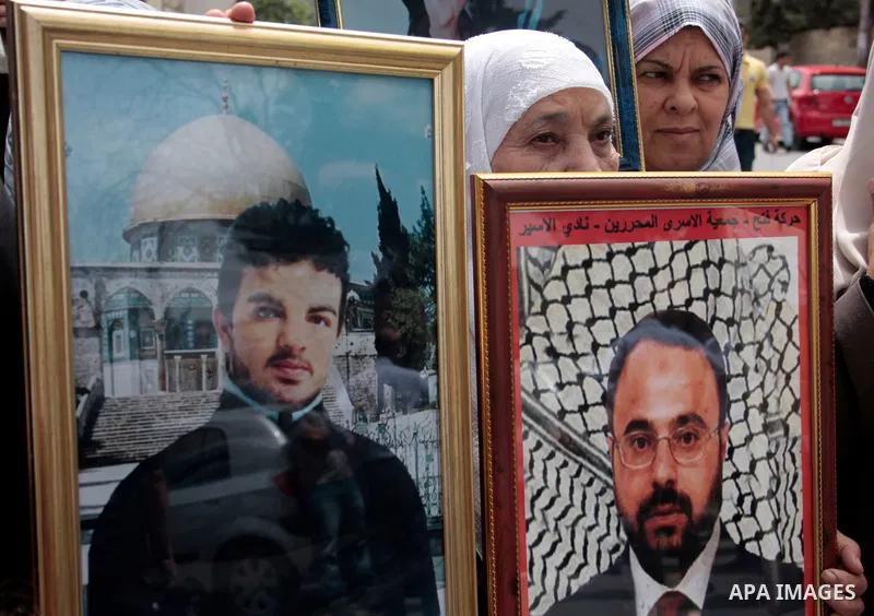 Palestinians hold up a photo of jailed family members as they take part in a rally, one of several taking place across the Israeli occupied West Bank and Gaza Strip, calling for the release of Palestinians being held in...