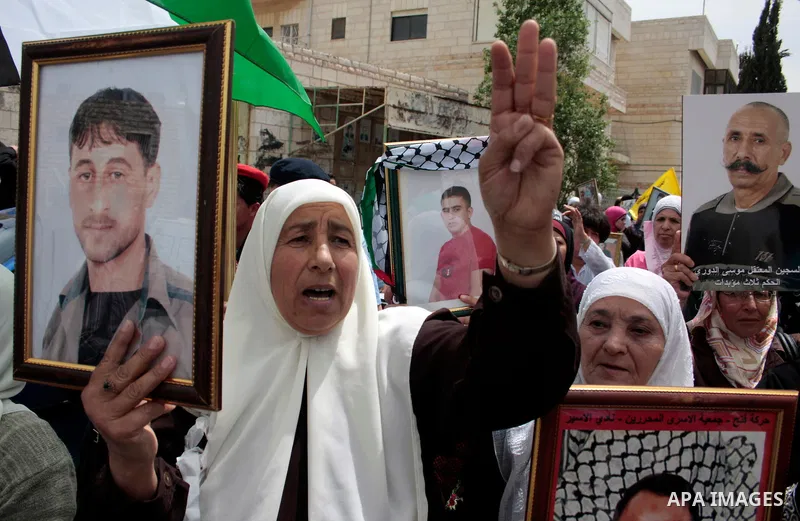 Palestinians hold up a photo of jailed family members as they take part in a rally, one of several taking place across the Israeli occupied West Bank and Gaza Strip, calling for the release of Palestinians being held in...