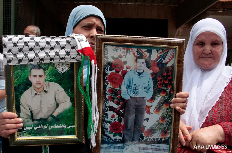 Palestinians hold up a photo of jailed family members as they take part in a rally, one of several taking place across the Israeli occupied West Bank and Gaza Strip, calling for the release of Palestinians being held in...