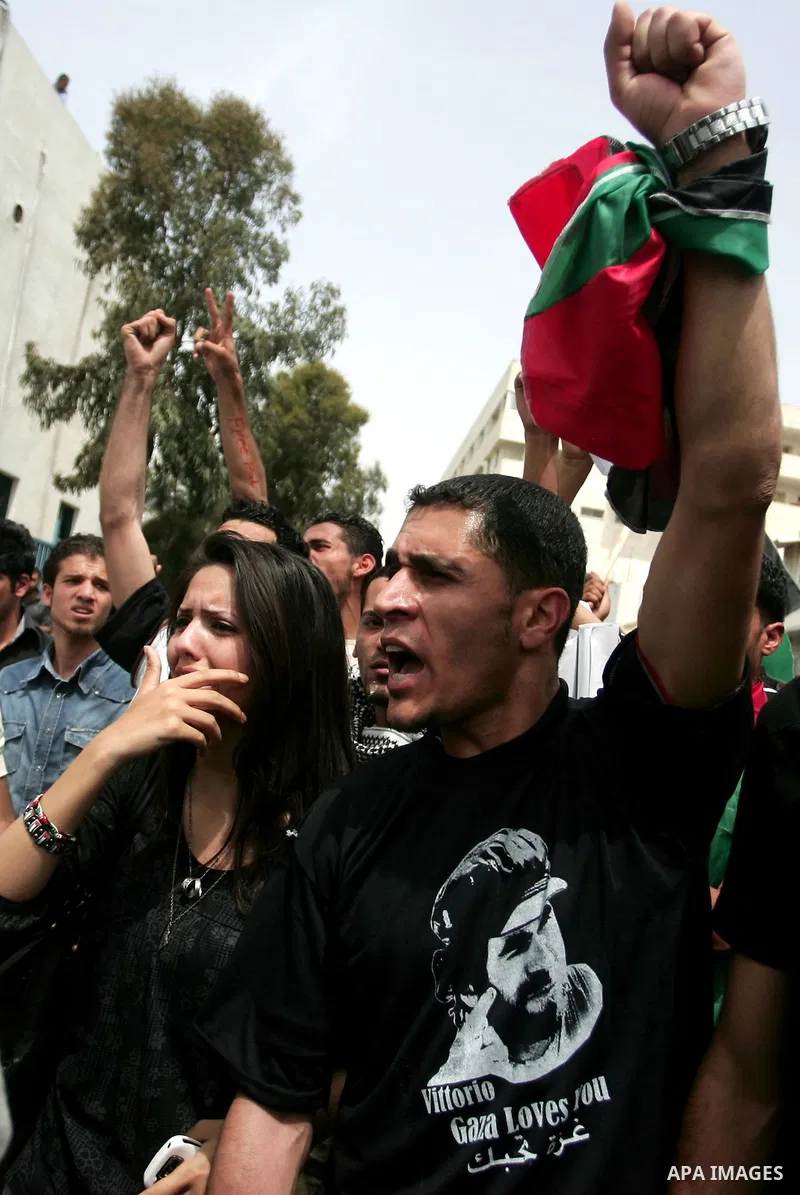 Palestinians react after the coffin of Italian activist Vittorio Arrigoni was removed from al-Shifa hospital in Gaza City April 18, 2011. Friends of the Italian activist Arrigoni arrived in Gaza to escort his body to Ita...