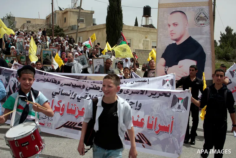 Palestinians hold up a photo of jailed family members as they take part in a rally, one of several taking place across the Israeli occupied West Bank and Gaza Strip, calling for the release of Palestinians being held in...