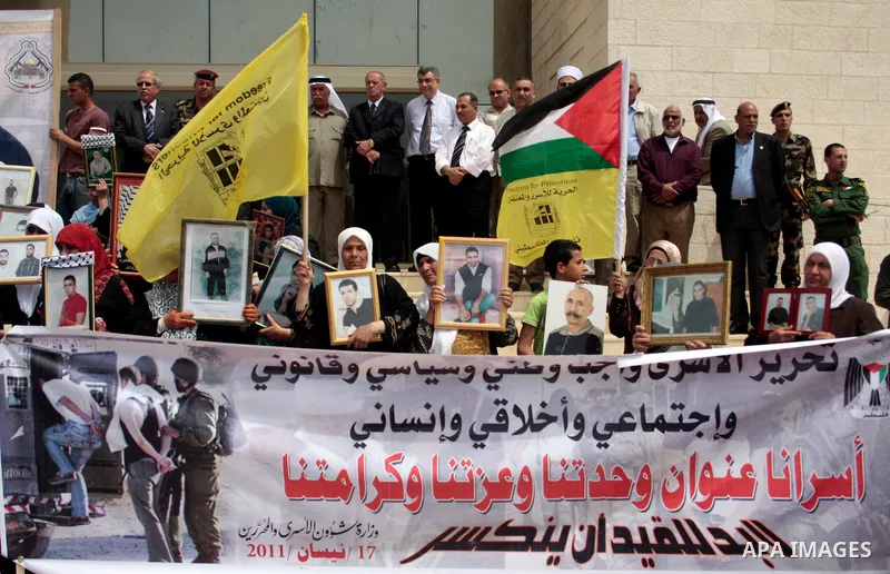 Palestinians hold up a photo of jailed family members as they take part in a rally, one of several taking place across the Israeli occupied West Bank and Gaza Strip, calling for the release of Palestinians being held in...
