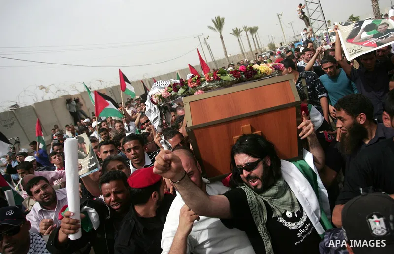 Palestinians chant slogans while carrying the coffin of Italian activist Vittorio Arrigoni, age 36, as they transfer it through Rafah border crossing in southern Gaza Strip, Monday, April 18, 2011. Gaza's Hamas governmen...