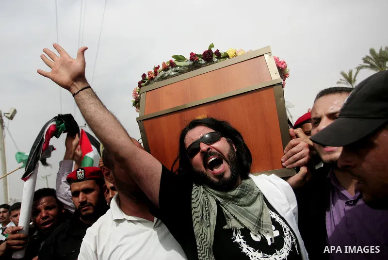 Palestinians chant slogans while carrying the coffin of Italian activist Vittorio Arrigoni, age 36, as they transfer it through Rafah border crossing in southern Gaza Strip, Monday, April 18, 2011. Gaza's Hamas governmen...