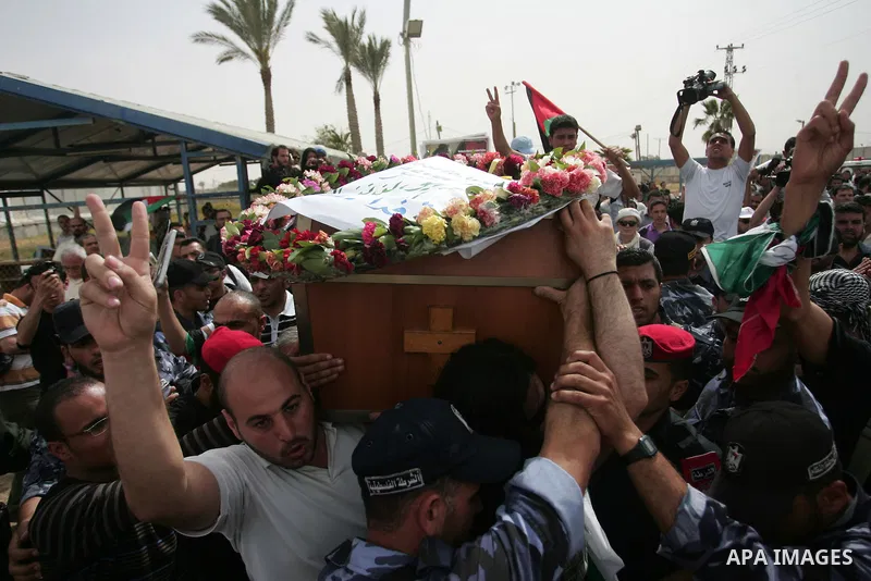Palestinians chant slogans while carrying the coffin of Italian activist Vittorio Arrigoni, age 36, as they transfer it through Rafah border crossing in southern Gaza Strip, Monday, April 18, 2011. Gaza's Hamas governmen...