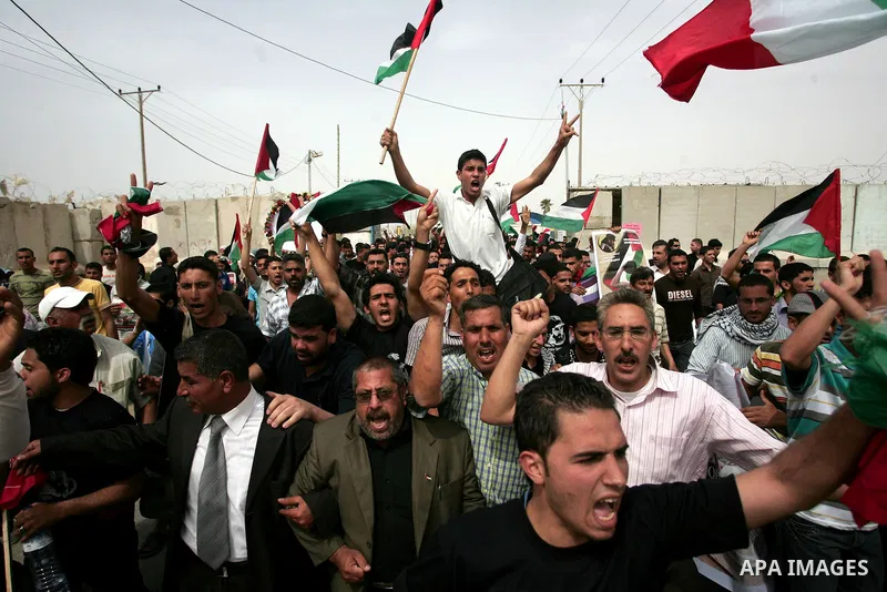 Palestinians chant slogans while carrying the coffin of Italian activist Vittorio Arrigoni, age 36, as they transfer it through Rafah border crossing in southern Gaza Strip, Monday, April 18, 2011. Gaza's Hamas governmen...