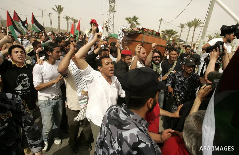 Palestinians and foreigners mourn during the "state funeral" of Italian activist Vittorio Arrigoni in Rafah, southern Gaza Strip, on April 18, 2011 before the transferring of his body to Egypt via the Rafah border crossi...