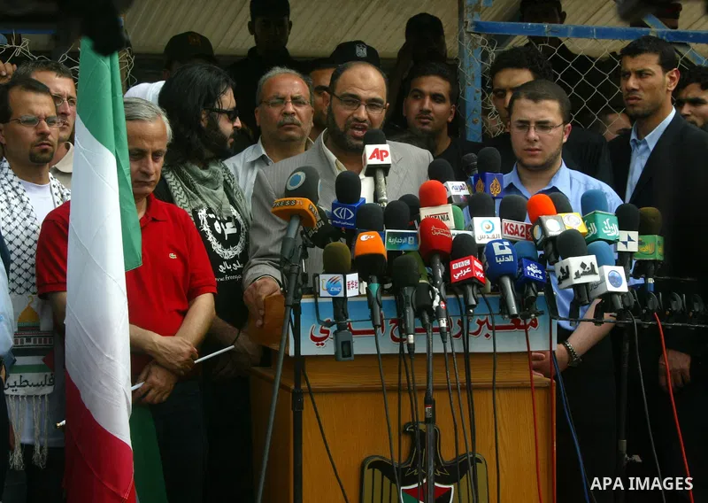 Hamas officials participate in a press conference as Palestinians and foreigners mourn during the "state funeral" of Italian activist Vittorio Arrigoni in Rafah, southern Gaza Strip, on April 18, 2011 before the transfer...