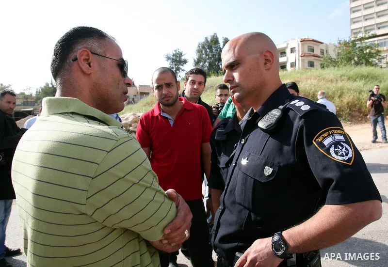 An Israeli policeman prevent Palestinian youths to lay a placard printed with Arabic name of a street during the project of Arabization of the streets in the neighborhood of Sheikh Jarrah in East Jerusalem on April 19,20...