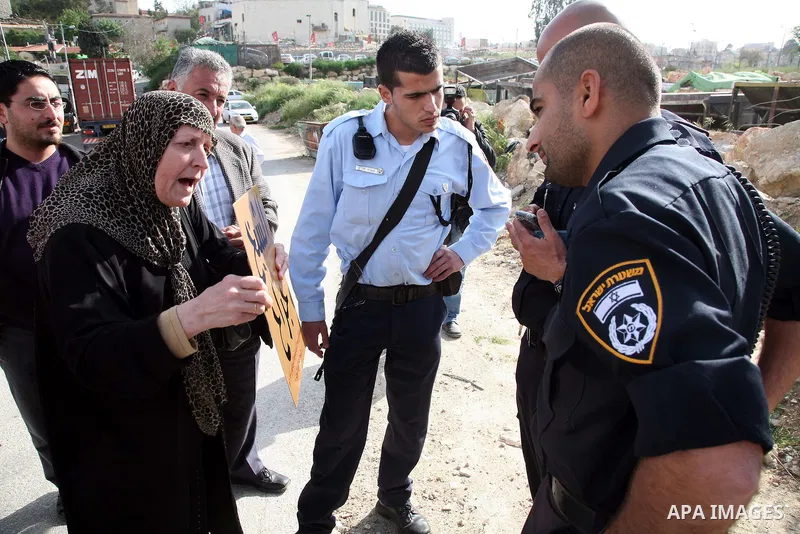 An Israeli policeman prevent Palestinians to lay a placard printed with Arabic name of a street during the project of Arabization of the streets in the neighborhood of Sheikh Jarrah in East Jerusalem on April 19,2011. Ph...