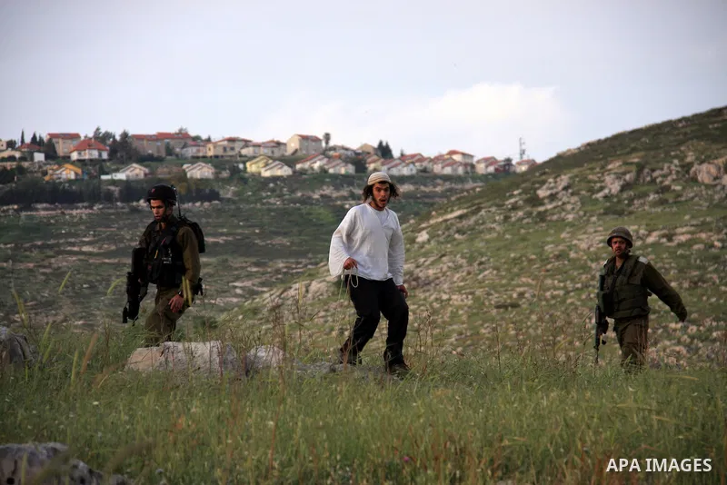 A Jewish settler from the Har Bracha settlement holds stones as he readies to lob them at local Palestinian villagers during clashes close to the Palestinian village of Burin in the Israeli occupied West bank on April 19...