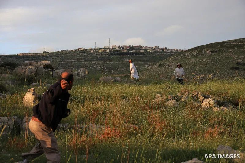 A Jewish settler from the Har Bracha settlement holds stones as he readies to lob them at local Palestinian villagers during clashes close to the Palestinian village of Burin in the Israeli occupied West bank on April 19...