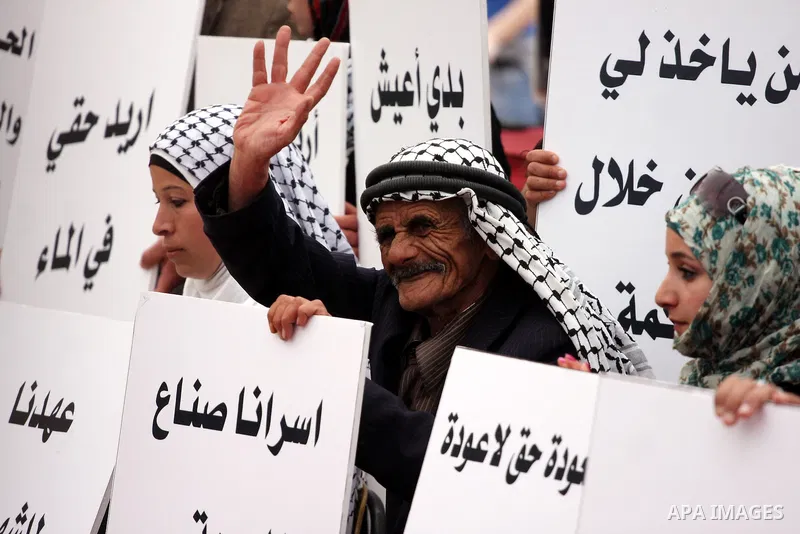 Palestinians hold up slogans during the opening ceremony of the 6th Bilin international conference for Palestinian Popular Resistance on April 20, 2011 in West Bank village of Bilin, near Ramallah. Fayyad called on the i...